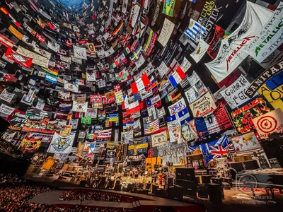 Fan flags and banners from around the world fill the Sphere before the show